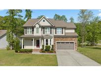 Charming two-story home with stone accents, manicured lawn, and neutral-toned siding at 130 Hilldebrant Dr, Franklinton, NC 27525
