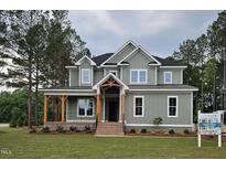 Charming two-story home with a welcoming porch and beautifully landscaped front yard at 15 Independence Dr, Smithfield, NC 27577