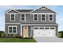 Charming two-story home featuring a gray facade, a front-facing two car garage, and a well-manicured lawn at 1595 Ivy Meadow Ln, Zebulon, NC 27597