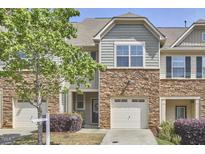 Charming townhouse with stone accents, well-maintained landscaping, and attached one car garage at 19 Sangre De Cristo Dr, Durham, NC 27705