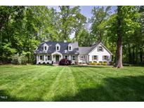 Charming white-painted home with a manicured lawn and mature trees at 202 Homestead Dr, Cary, NC 27513