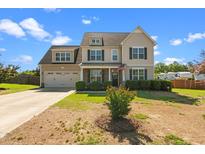 Charming two-story home featuring a manicured lawn and an inviting covered porch at 244 N Prince Henry Way, Cameron, NC 28326