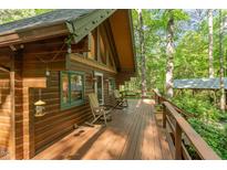 Expansive wooden deck features rocking chairs and overlooks lush greenery at 300 Rabbit Run, Pittsboro, NC 27312
