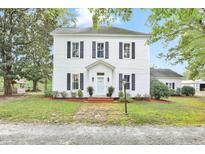 Charming white two-story home featuring black shutters and a brick path leading to the front door at 3521 Banks Rd, Raleigh, NC 27603