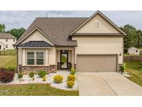 Charming home with stone accents, manicured landscaping, and a two-car garage at 404 Lily Pad Ct, Zebulon, NC 27597
