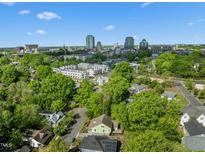 Stunning aerial view featuring downtown skyline and surrounding neighborhood with mature trees and manicured lawns at 501 Mallard Ave, Durham, NC 27701
