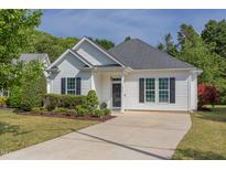 Charming single-story home with white siding, black shutters, manicured landscaping, and a concrete driveway at 715 Barlang Cir, Fuquay Varina, NC 27526