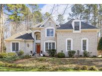 Beautiful two-story home with white brick exterior and well-maintained landscaping at 7420 Heartland Dr, Wake Forest, NC 27587