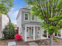 Charming two-story home featuring a welcoming front porch with rocking chairs and beautiful landscaping at 7829 Acc Blvd, Raleigh, NC 27617