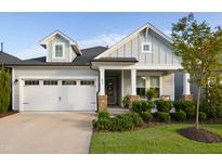 Charming single Gathering home featuring a two-car garage and a welcoming front porch at 825 Flower Manor Dr, Wendell, NC 27591