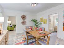 Bright dining room featuring a colorful rug, table set for four, and views into the living room at 919 Orient St, Durham, NC 27701
