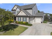 Charming two-story home with a 3-car garage, manicured lawn and beautiful landscaping at 1010 Smoke Willow Way, Rolesville, NC 27571