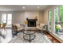 Bright living room with fireplace, hardwood floors, stylish rug and furniture at 104 Silver Fox Ct, Cary, NC 27511
