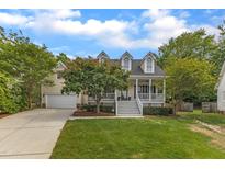 Charming two-story home featuring a welcoming front porch, well-manicured lawn and a two car garage at 106 Kenneil Ct, Apex, NC 27502