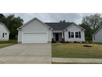 Charming single-story home with gray siding, a two-car garage, and a well-maintained lawn at 115 Oakfield Trace Dr, Four Oaks, NC 27524