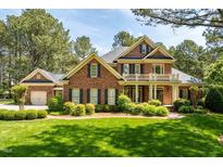 Beautiful two-story red brick home featuring a second story balcony and well-manicured front yard at 1317 Colonial Club Rd, Wake Forest, NC 27587
