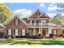 Traditional brick home with a welcoming front porch and manicured landscaping at 1317 Colonial Club Rd, Wake Forest, NC 27587
