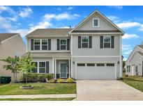 Charming two-story home featuring a two-car garage, well-manicured lawn, and inviting front porch at 1410 Arena Ln, Fuquay Varina, NC 27526