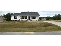 Charming single-story home with white siding and a well-manicured lawn on a cloudy day at 146 Starry Sky Dr, Benson, NC 27504