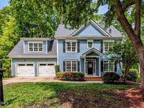 Charming two-story home with a well-manicured lawn, three-car garage and welcoming front porch at 204 Flint Point Ln, Holly Springs, NC 27540
