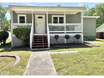 Charming home with a welcoming front porch, well-maintained lawn, and beautiful landscaping at 2101 S Roxboro St, Durham, NC 27707