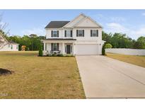 Charming two-story home with a well-manicured lawn and a welcoming front porch at 214 Thumper Way, Clayton, NC 27520