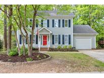 Charming two-story home with a bright red front door, black shutters, and well-maintained landscaping at 2205 Long And Winding Rd, Raleigh, NC 27603