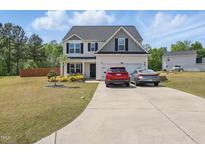 Charming two-story home with manicured lawn, attached garage, and driveway at 227 Sumter Ct, Burlington, NC 27217