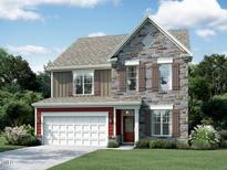 Charming two-story home featuring stone facade, brown wood shutters, and a two-car garage at 2393 Picual Way # 22, New Hill, NC 27562