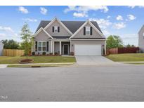 Charming two-story home with a manicured lawn, attached garage, and welcoming entrance, perfect for a growing Gathering at 270 Oak Park Blvd, Youngsville, NC 27596