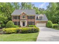 Charming brick home featuring black shutters, a well-manicured lawn, and a two car garage at 408 Evert Dr, Cary, NC 27511
