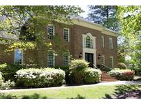 Beautiful brick home featuring a black front door, manicured landscaping and steps leading to the entrance at 4101 John S Raboteau Wynd, Raleigh, NC 27612