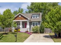 Charming home with a red door, beautiful landscaping, and a well-maintained lawn at 507 Canal St, Durham, NC 27701