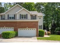 Charming two-story townhome with a brick front, attached garage, and well-manicured landscaping at 5610 Picnic Rock Ln, Raleigh, NC 27613