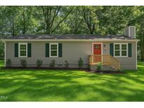 Charming home featuring gray siding, a bright red front door, and lush green lawn at 567 Howard Tant Rd, Zebulon, NC 27597