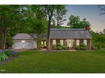 Charming brick home with a lush green lawn and a welcoming two-car garage at 615 Beaver Creek Rd, Apex, NC 27502