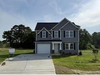 Charming two-story home with gray siding, black shutters, and a well-manicured front lawn at 63 Coharie Dr, Lillington, NC 27546