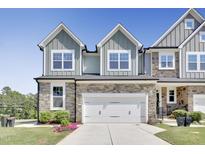 Beautiful townhome featuring a stone facade, 2-car garage and manicured landscaping at 8426 Garnet Rose Ln, Raleigh, NC 27615