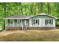 Charming single-story home with a brick foundation, green siding, and a cozy front porch at 104 Argyle Ct, Garner, NC 27529