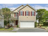 Charming two-story home with a well-manicured lawn, inviting entrance, and red shutters at 104 Caley Rd, Apex, NC 27502