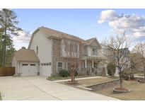 Charming two-story home with a stone and vinyl facade, attached garage, and well-manicured front yard at 1040 Austin Pond Dr, Cary, NC 27519