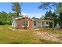 Charming single-story home with white siding and brick accents, surrounded by a green lawn at 108 Deepwood Cir, Garner, NC 27529