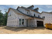 Two-story home featuring an attached garage, visible construction materials, and a traditional roofline at 1252 Randwick Valley Ct Ct, Zebulon, NC 27597
