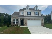 Charming two-story home with brick accents, a two-car garage, and a well-maintained front lawn at 1252 Randwick Vly Ct, Zebulon, NC 27597