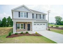 Beautiful two-story home with gray siding, stone accents, and a manicured lawn at 127 High Hampton Way, Fuquay Varina, NC 27526