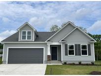 Charming home with gray siding, black shutters, gray garage door, and well-manicured lawn at 127 Oakfield Trace Dr, Four Oaks, NC 27524