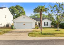 Charming single-story home with a well-manicured front yard and a two-car garage at 1725 E Honey Springs Ave, Fuquay Varina, NC 27526