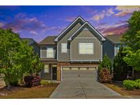 Charming two-story home featuring neutral siding, stone accents, attached garage, and landscaped yard at 205 Begen St, Morrisville, NC 27560
