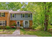 Charming two-story townhouse with a well-maintained yard, brick accents, and beautiful blue shutters at 225 Bay Dr, Cary, NC 27511