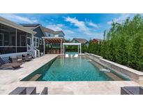 Inviting backyard pool featuring a sun-shelf, water feature, and outdoor seating area at 400 Chickasaw Plum Dr, Holly Springs, NC 27540
